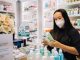 woman in black shirt holding a hand sanitizer bottle