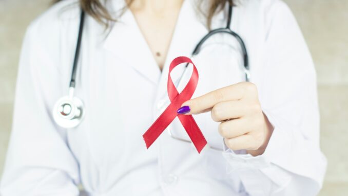 a woman in a white shirt holding a red ribbon