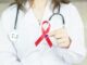 a woman in a white shirt holding a red ribbon