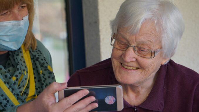 woman in brown button up shirt holding white smartphone