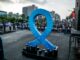 A large blue ribbon is on display in the middle of a street
