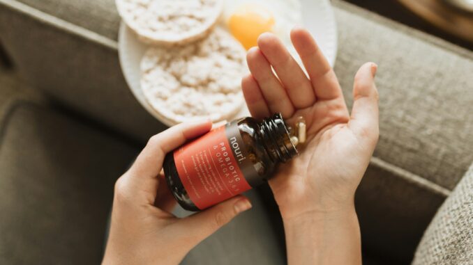 person holding red bottle