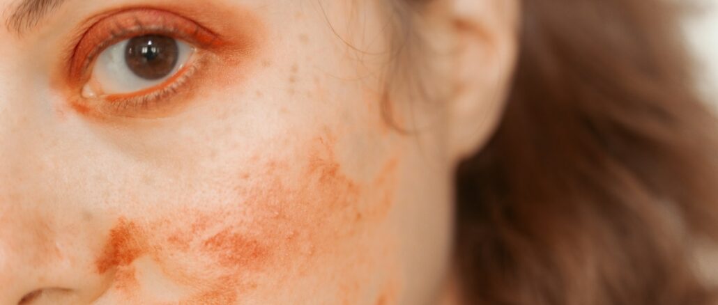 Woman with red paint smudges on face