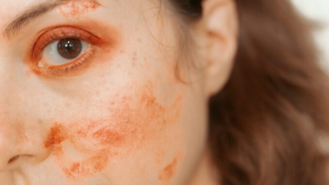Woman with red paint smudges on face
