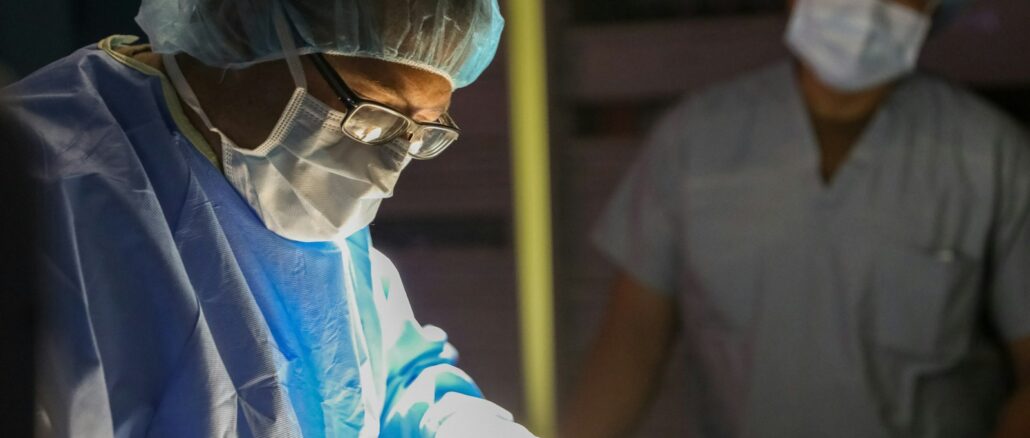 Surgeons in sterile gowns and masks performing surgery