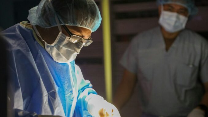 Surgeons in sterile gowns and masks performing surgery